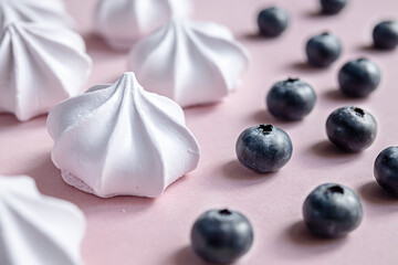 French berry meringue cookies or marshmallow and blueberries on the table close-up