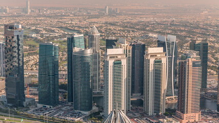 Jumeirah Lakes Towers district with many skyscrapers along Sheikh Zayed Road aerial timelapse.