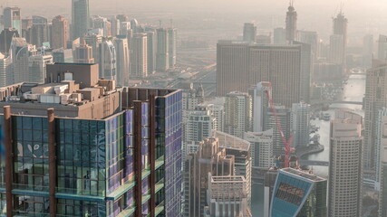 Dubai Marina and JLT district with traffic on highway between skyscrapers aerial timelapse.