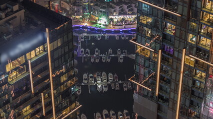 Looking down view perspective on night highlighted luxury Dubai Marina skyscrapers night timelapse, Dubai, United Arab Emirates