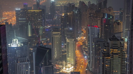View of Dubai Marina showing canal surrounded by skyscrapers along shoreline night to day...