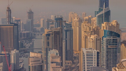 Fototapeta na wymiar Skyline panoramic view of Dubai Marina showing an artificial canal surrounded by skyscrapers along shoreline timelapse. DUBAI, UAE