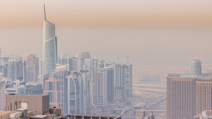 Jumeirah Lakes Towers district with many skyscrapers along Sheikh Zayed Road aerial timelapse.