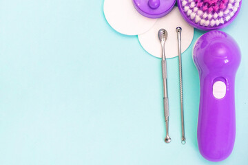 uno scoop and facial massager are on a soft turquoise background. flat lay, cosmetology