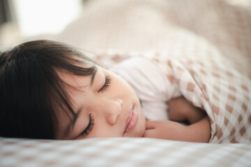 Obraz na płótnie Canvas child little girl sleeps in the bed with a toy teddy bear