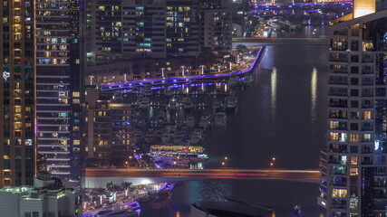 View of Dubai Marina showing canal surrounded by skyscrapers along shoreline night timelapse. DUBAI, UAE