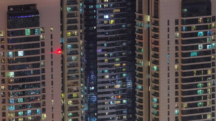 Fototapeta na wymiar Light in windows of modern towers. Exterior of apartment building at night with glowing windows timelapse.