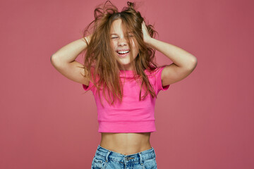 Energetic naughty hooligan little child girl ruffle long blond hair, having fun. Child's hairs...