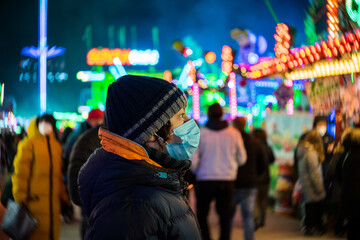 Fototapeta na wymiar A teenager at a Christmas market during COVID-19 pandemic restrictions.