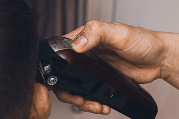 Hair clipper in hairdresser's hand.