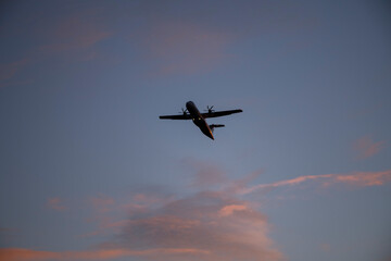 Air plane leaving the airport Bromma an early winter morning with glowing red clouds in Stockholm