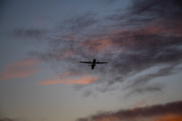 Fototapeta na wymiar Air plane leaving the airport Bromma an early winter morning with glowing red clouds in Stockholm