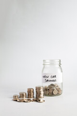Concept of saving money and growing value over time, piles of silver coins compounding and growing next to a jar with coins in labeled new car savings
