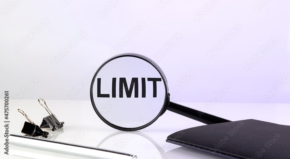 Poster limit concept. magnifier glass with text with notebook and pen