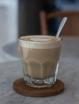 A Glass Of Hazelnut Latte On A Ceramic Table