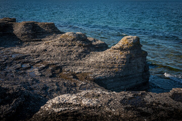 Limestone cliffs at coast of the island Oland in Sweden with sun and blue sky.