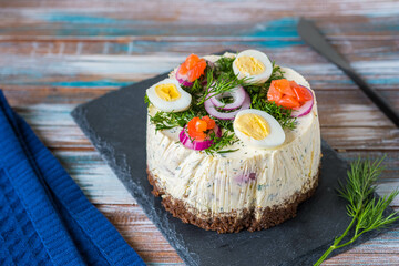 Snack, round Swedish salad cake with herring, potatoes, egg and sour cream mousse on black bread on...
