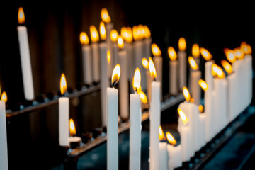 Religion background with burning white candles on fireplace at Church