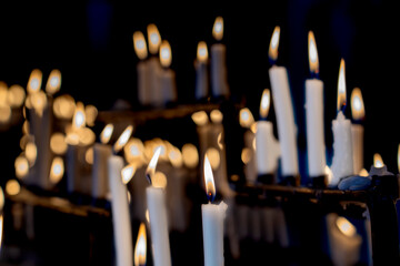 Religion background with burning white candles on fireplace at Church