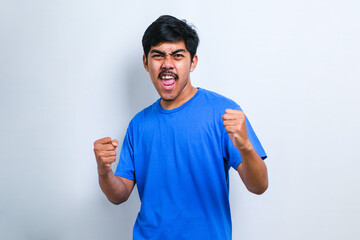 Fototapeta premium Asian man very happy and excited doing winner gesture with arms raised, smiling and screaming for success