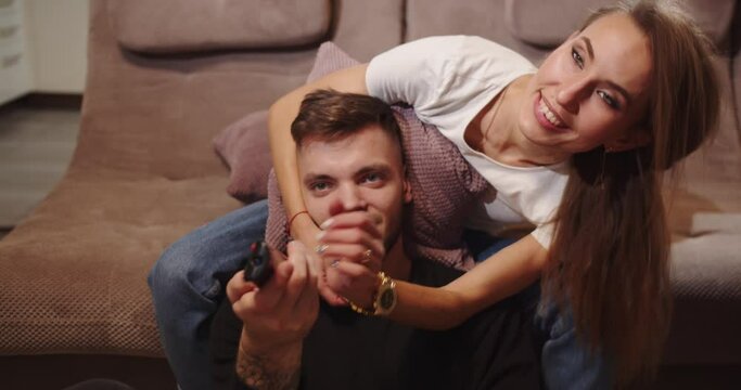 Guy with girl laughing and watching tv.