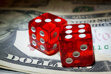 two red dice on dollar banknote under spot of hard light