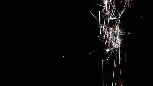Loop video Fireworks flame and sparks on black background. Close up flames ignite and sparkles isolated on black background. 