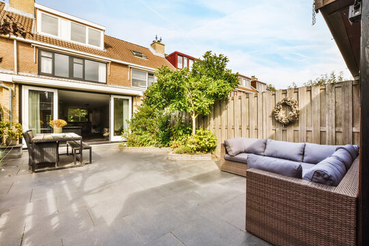 Amazing Courtyard Design With Wicker Sofas And Lots Of Greenery