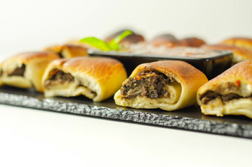 Patty's pies stuffed with minced meat, mushrooms and onion, served with sauce