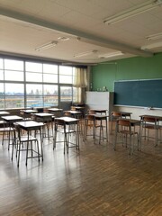 無人で机と椅子が並んだ寄木の床の日本の田舎の学校の教室の前方