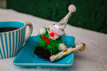 Christmas grandpa's toy on a blue saucer with a striped cup 