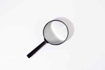 Magnifier with black frame lies on white isolated background