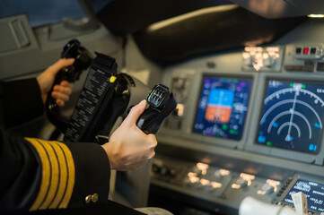 The hands of a female pilot at the helm of an airplane. Caucasian woman in flight simulator.
