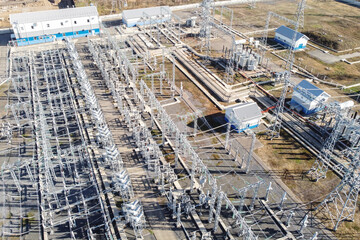 High-voltage electric transformation power plant. Industrial high-voltage power lines on pylons and...