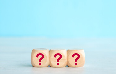 Wooden cube with Question mark icon on wooden table.