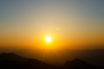 Scene of sunset or sunrise on the mountain in the summer with a yellow-blue sky background. Landscape.
