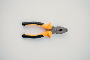 Fototapeta premium Closed pliers lie on white isolated background, tool for repair work