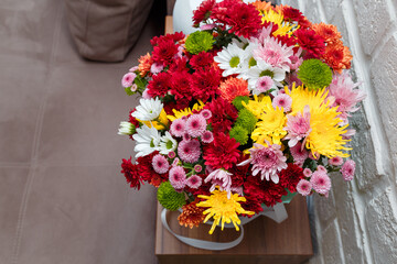 Beautiful autumn bouquet of multicolored chrysanthemums. Birthday, anniversary, Valentines day, women day present, flowers surprise. Close up, top view.