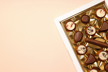 Concept of sweets with chocolate candies on beige background
