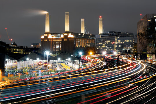 Light trails of passing trains heading in and out of London Victoria with Battersea Power Station in the background.