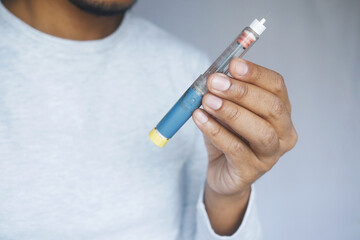 young man holding insulin pen close up  - obrazy, fototapety, plakaty