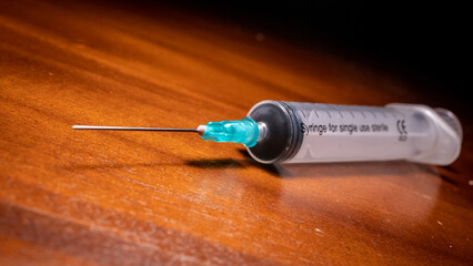 Syringe ready for vaccination on a wooden surface