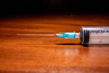 Syringe ready for vaccination on a wooden surface
