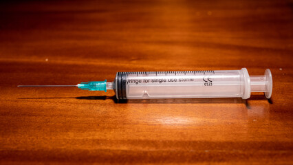 Syringe ready for vaccination on a wooden surface