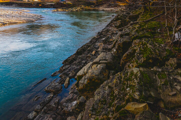A river among the mountains in late autumn. Atmospheric landscape with a mountain river. River valley among the mountain hills on an autumn day. Nature of the foothills of the Caucasus.