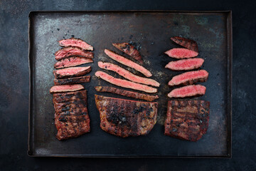 Traditional barbecue wagyu gourmet beef steaks served as top view on a rustic black board