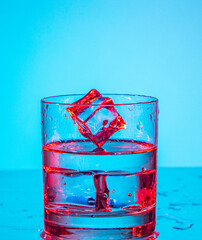 ice cubes falling into glass of water