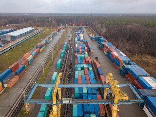 Multicolored freight containers at the railway customs. Aerial drone view.