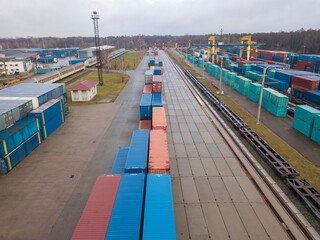 Multicolored freight containers at the railway customs. Aerial drone view.