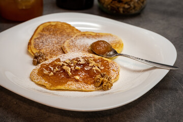 Pancakes with jam and walnuts on plate